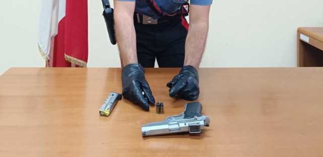 TORPE NU. MINACCIA LA RIVALE CON UNA PISTOLA CARICA DETENUTA ABUSIVAMENTE DAL MARITO